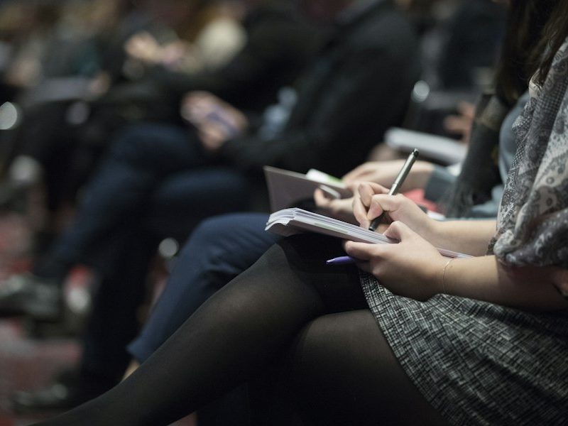 Asistentes tomando notas en una capacitación